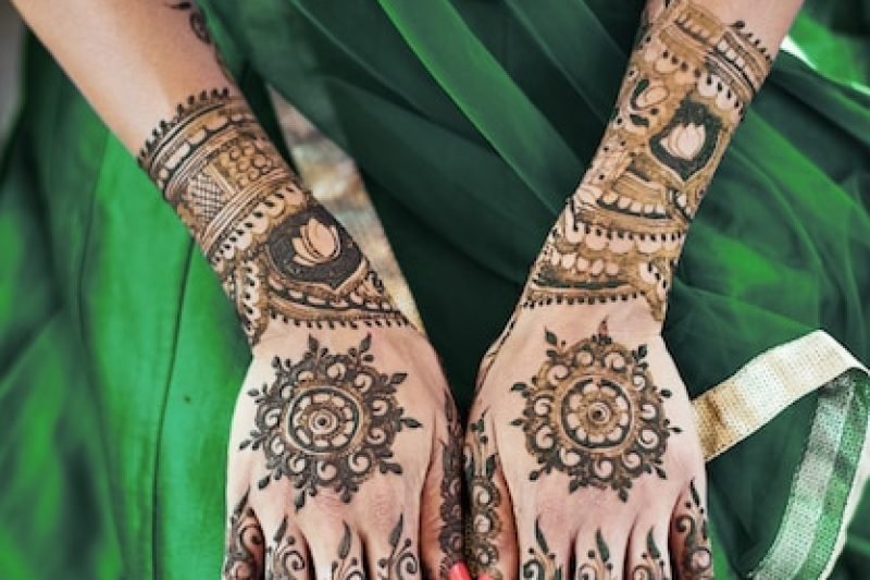 close-up-indian-bride-back-hand-with-mehndi-henna-tattoo-with-beautiful-sari_42422-247